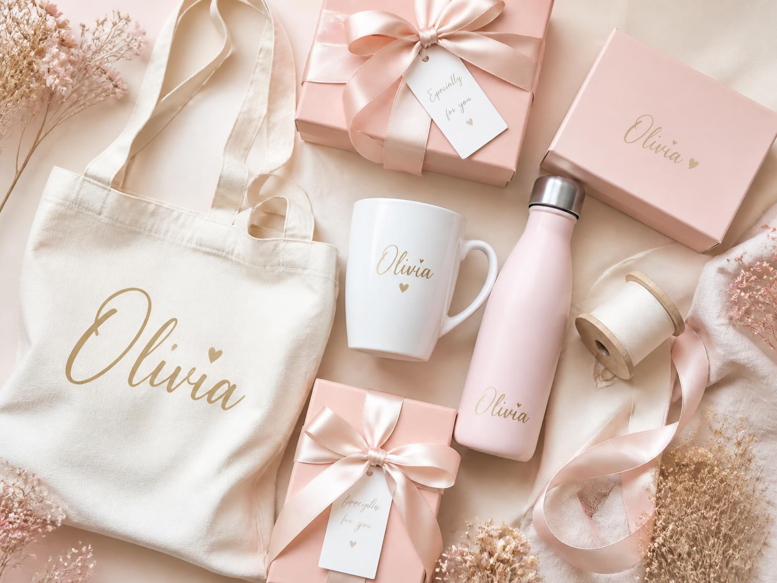 Personalised mugs, bottles, tote bags, gift boxes and ribbons arranged together